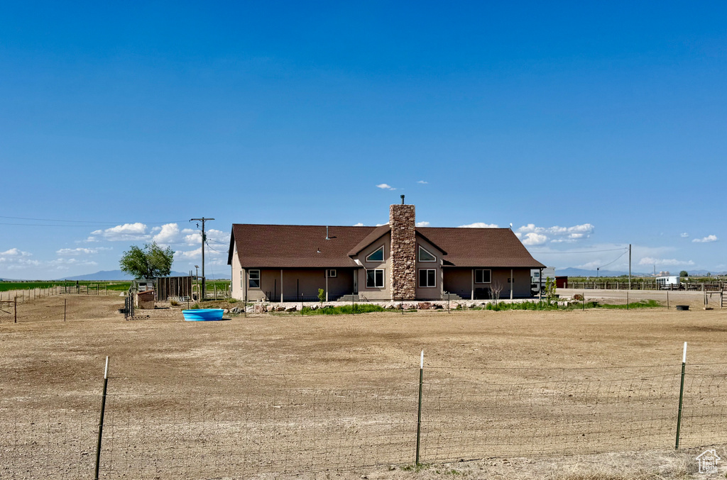 Rear view of property with a chimney and a rural view