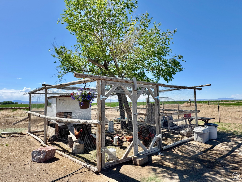 View of yard featuring exterior structure, an outdoor structure, and a view of rural / pastoral area