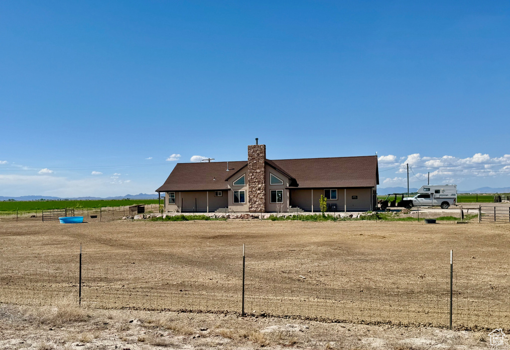 Back of property with a chimney, a view of countryside, and a mountain view