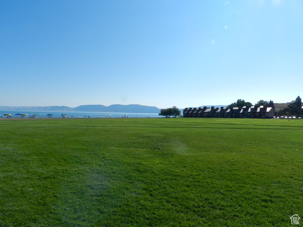 View of property\'s community with a mountain view, a lawn, and a rural view