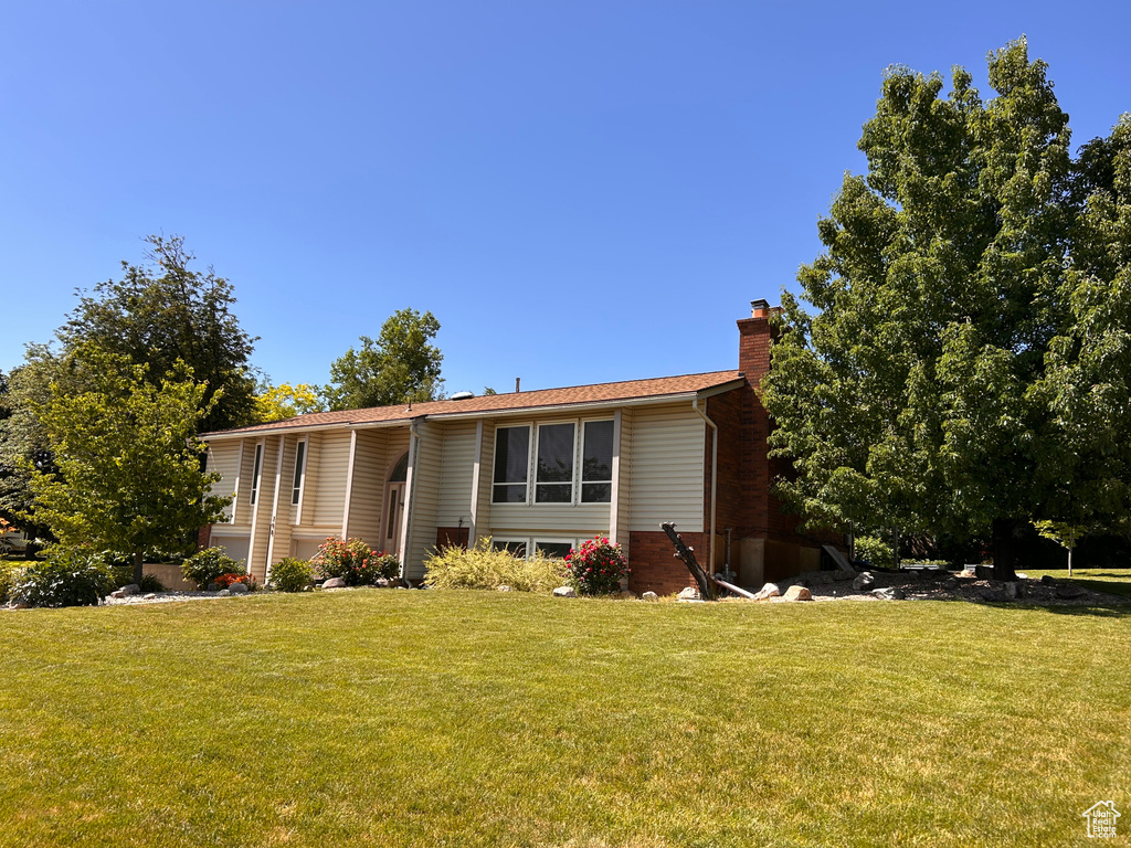 View of front of property with a chimney and a front lawn