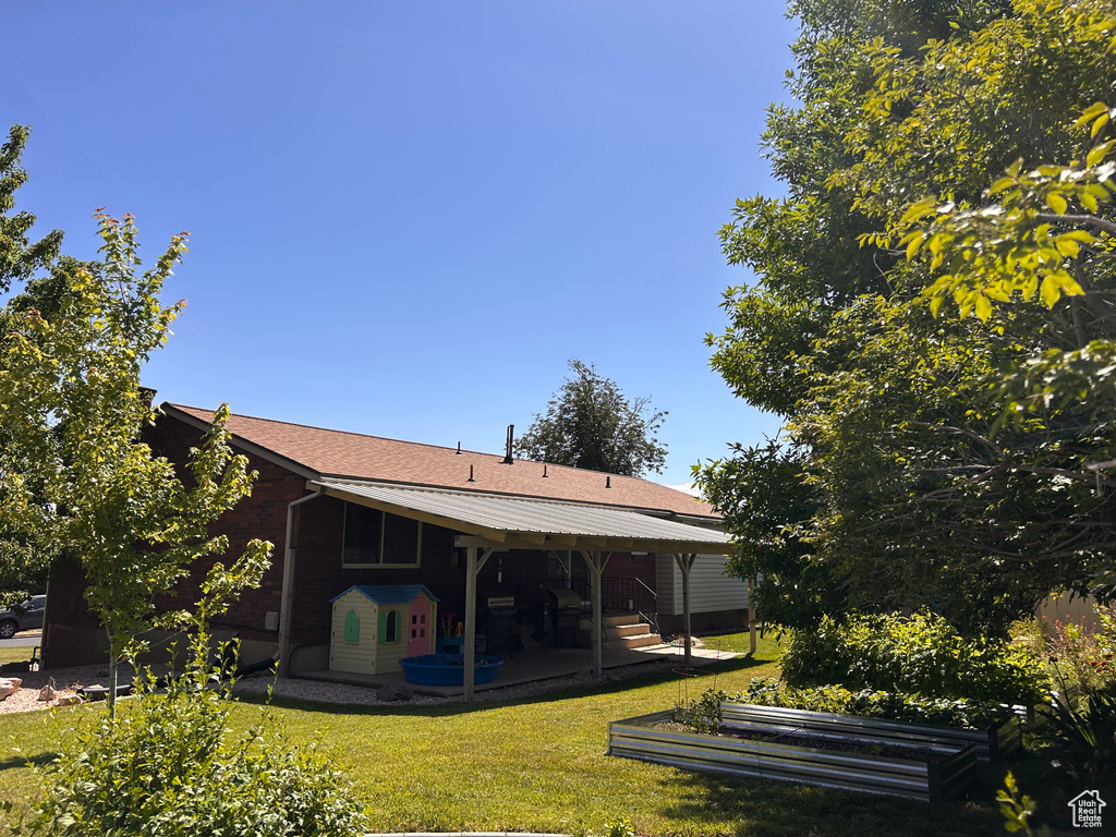 Rear view of house with a patio and a yard