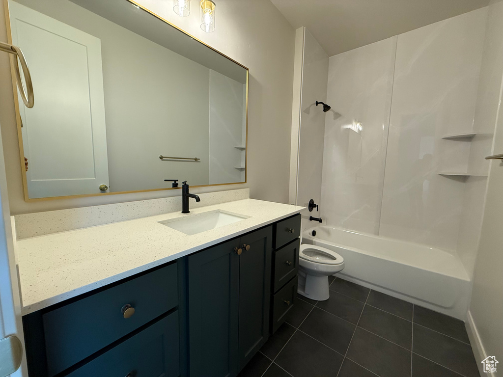 Bathroom featuring tile patterned flooring, vanity, toilet, and washtub / shower combination