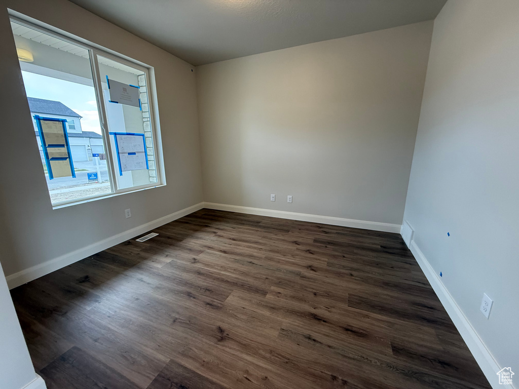 Unfurnished room with dark wood-type flooring and baseboards