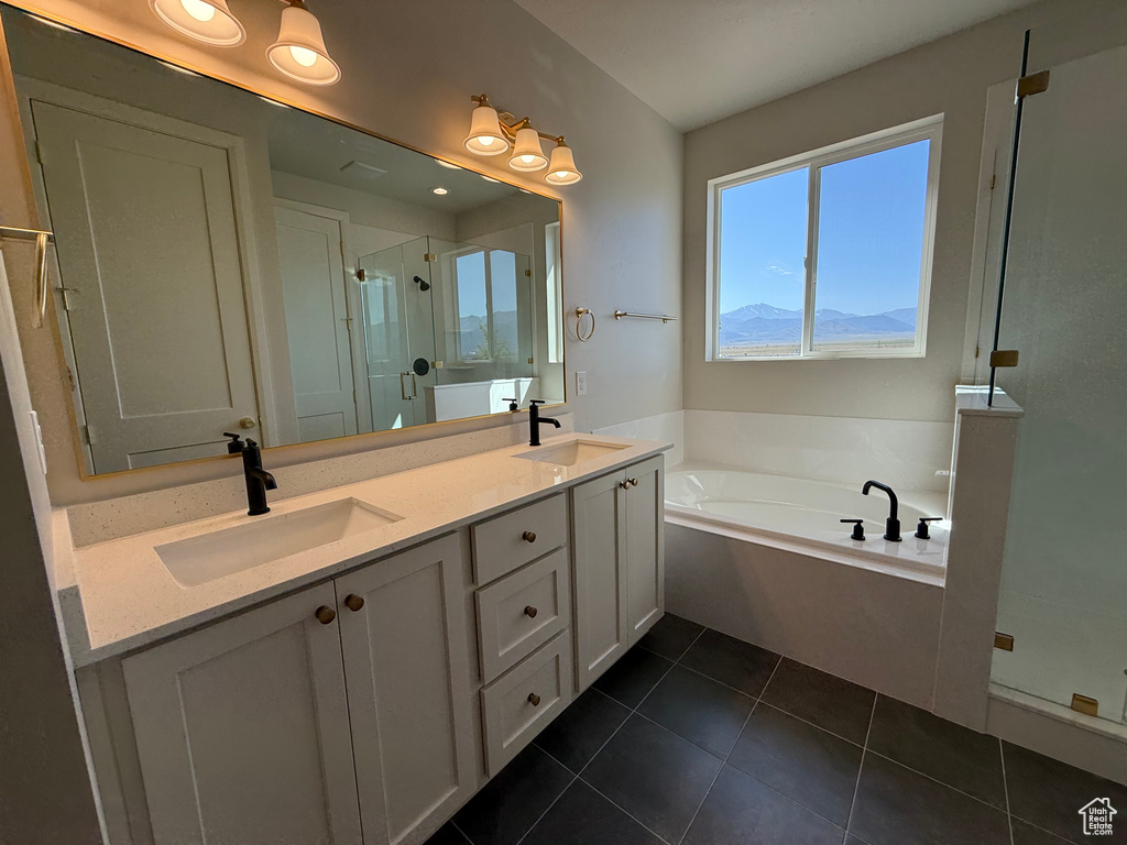 Bathroom featuring a shower stall, a bath, double vanity, and tile patterned floors