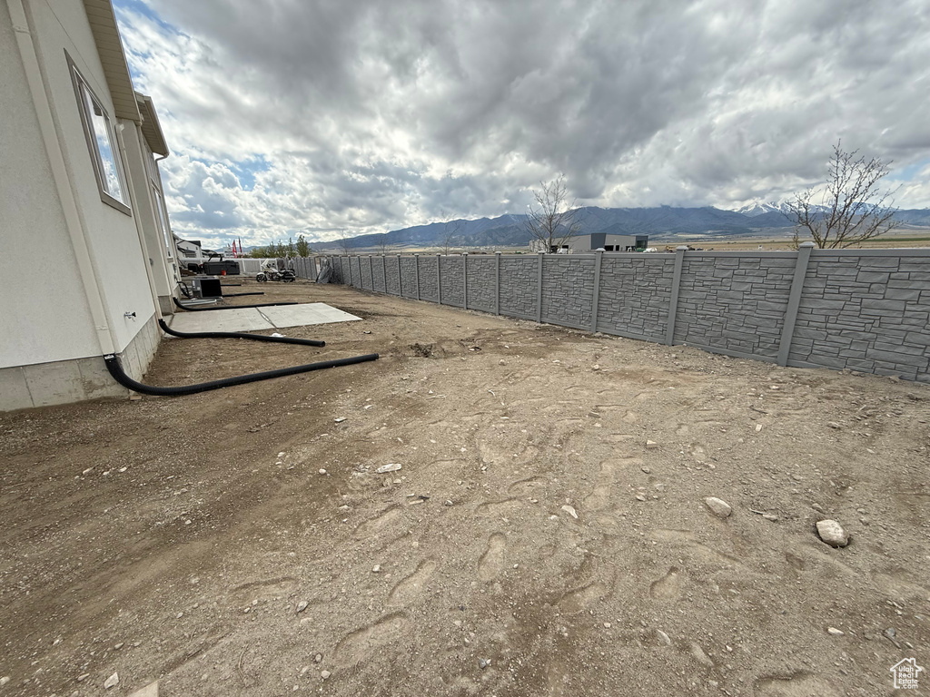 View of yard featuring a mountain view and fence