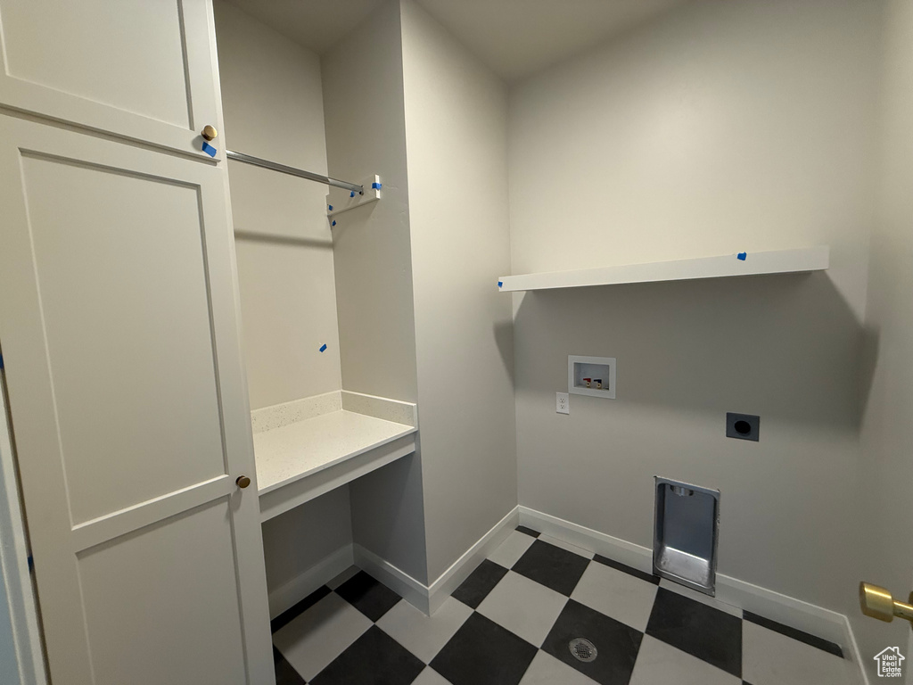 Washroom with hookup for a washing machine, electric dryer hookup, dark flooring, and baseboards