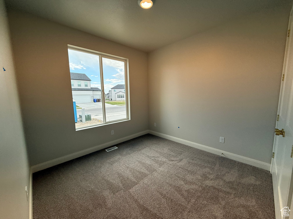Carpeted spare room with baseboards