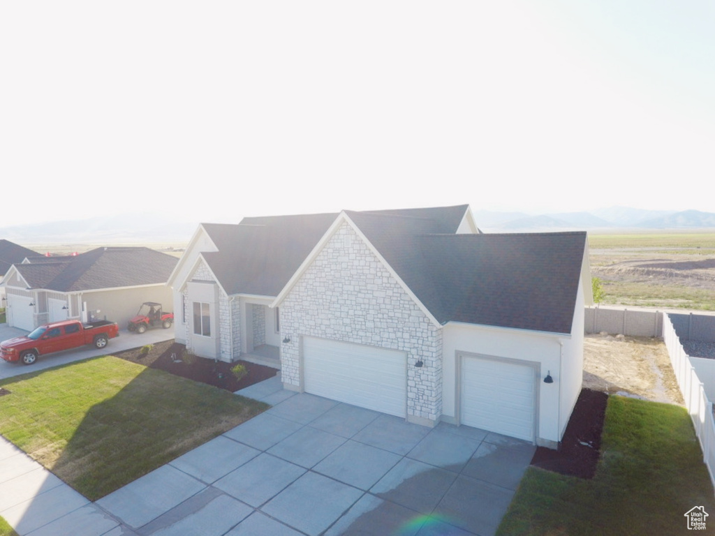 Ranch-style house with a garage, driveway, and stone siding