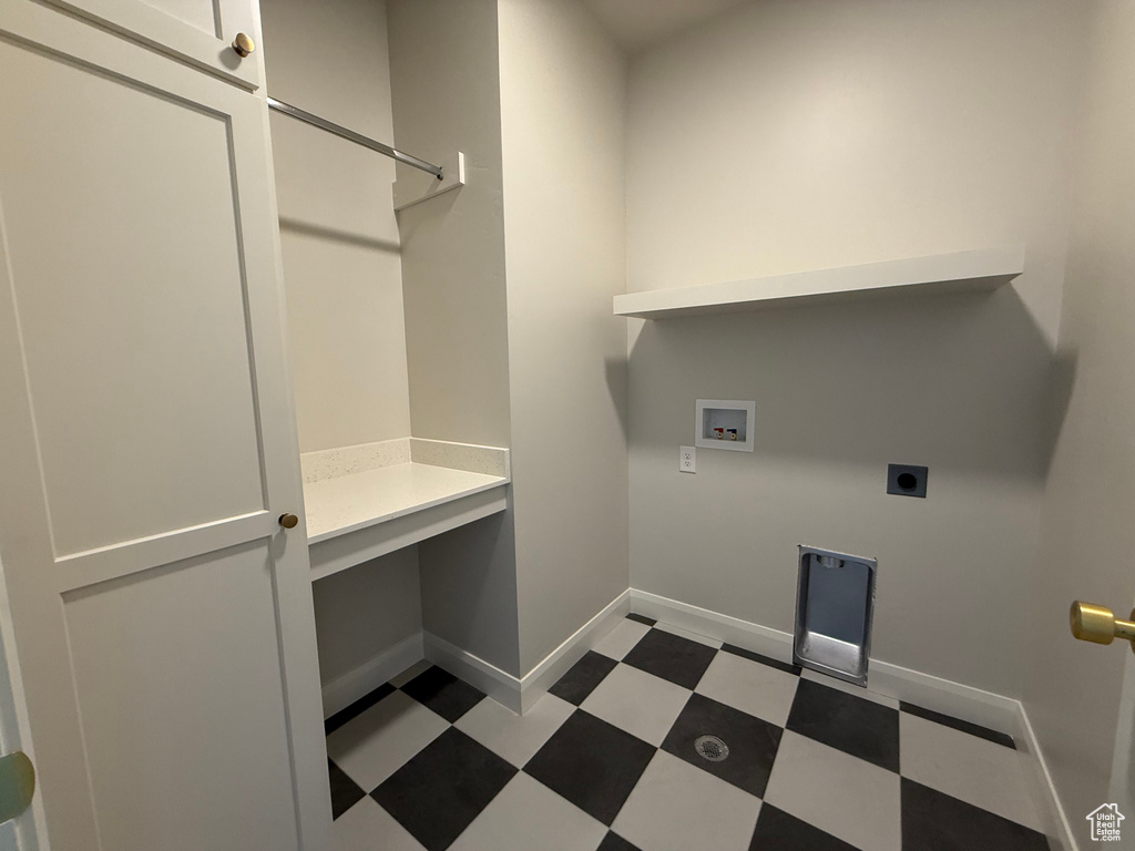 Laundry area featuring hookup for a washing machine, electric dryer hookup, tile patterned floors, and baseboards