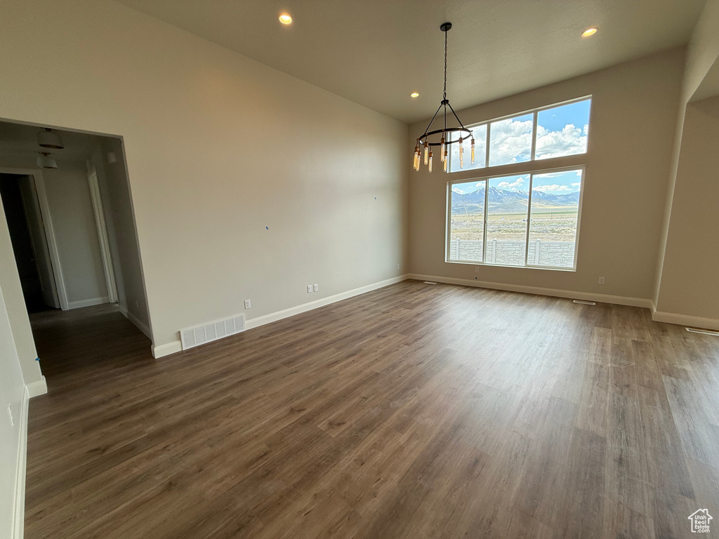 Unfurnished dining area with a chandelier, dark wood finished floors, recessed lighting, and baseboards