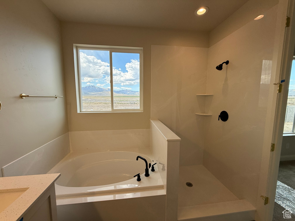 Bathroom with a garden tub, a shower, vanity, and recessed lighting