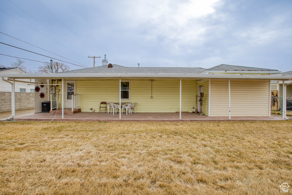 Rear view of property featuring a patio, a yard, and central AC unit
