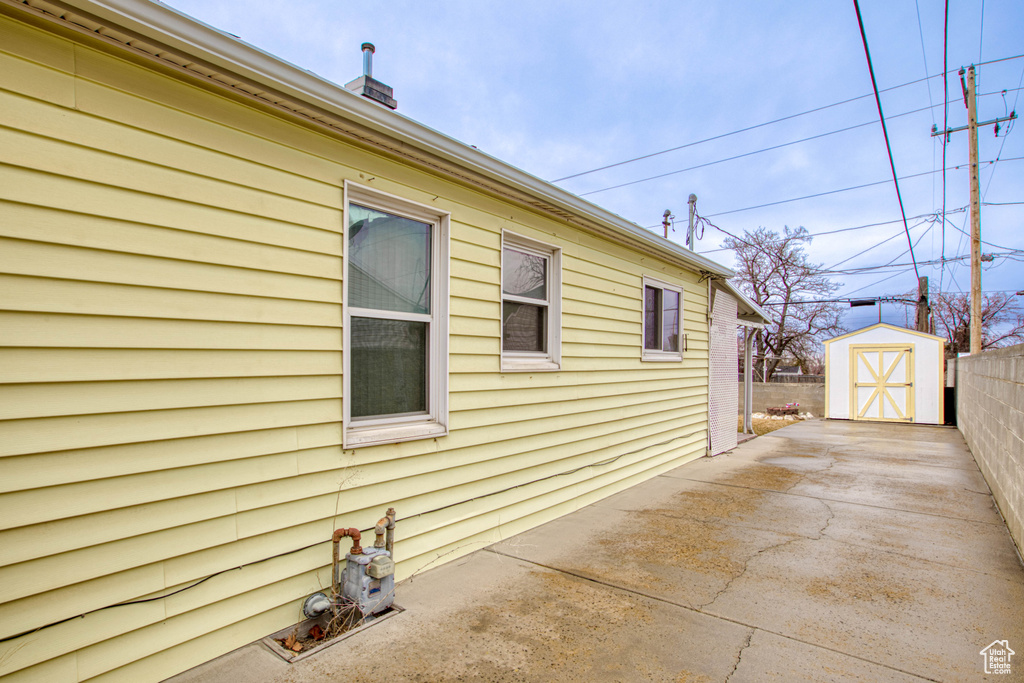 View of home\'s exterior featuring a storage shed and a patio area
