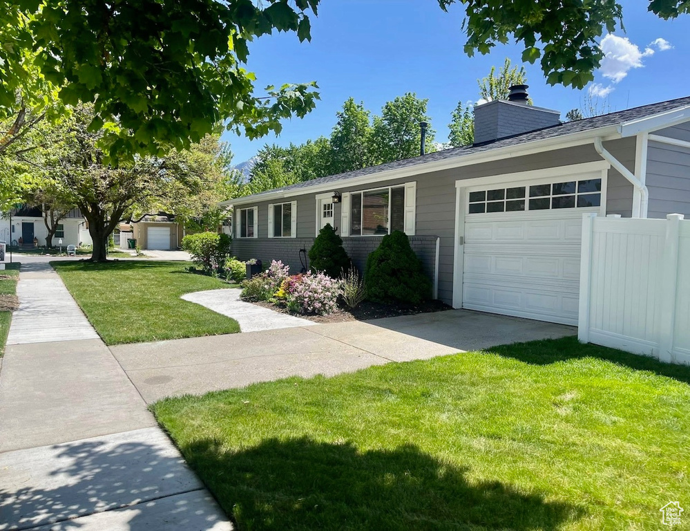 Ranch-style home featuring an attached garage and a chimney