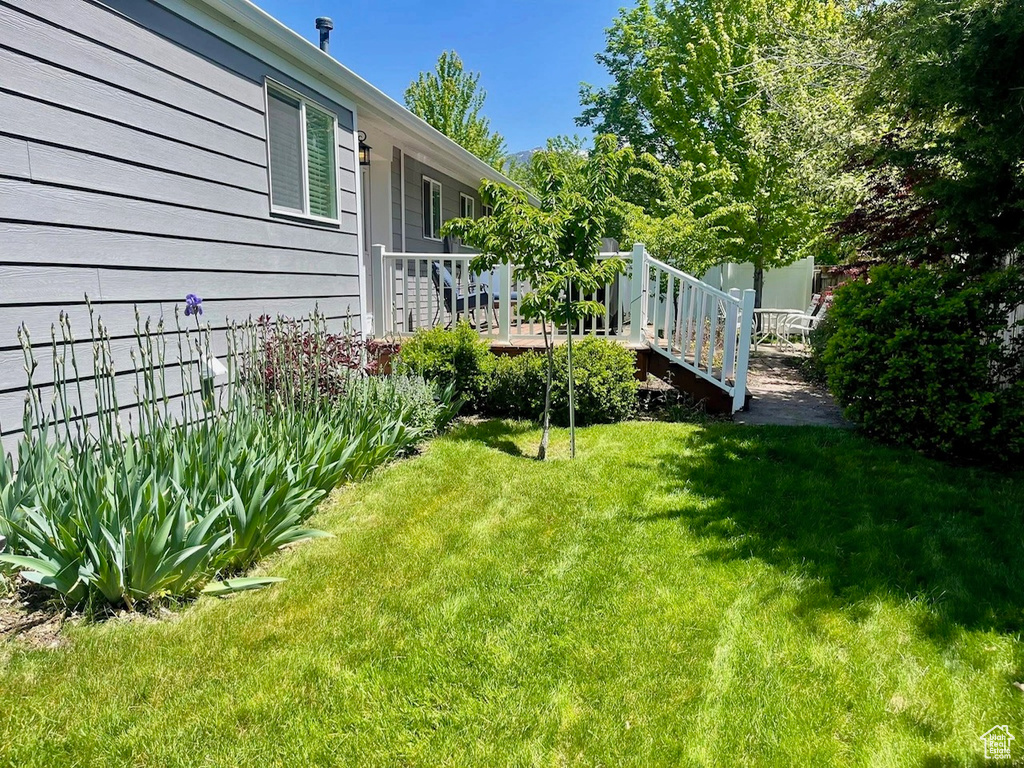 View of grassy yard with a deck