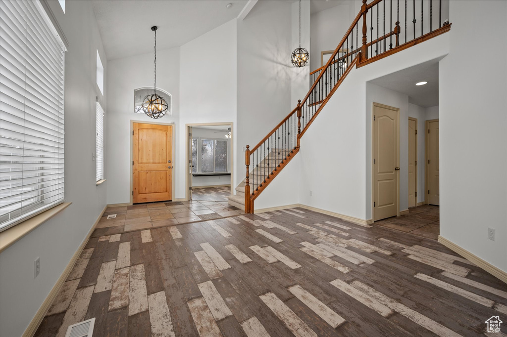 Entryway featuring a high ceiling, a healthy amount of sunlight, and hardwood / wood-style floors