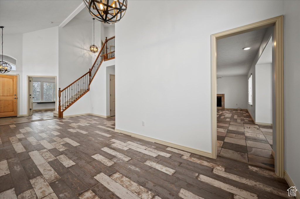 Entrance foyer featuring an inviting chandelier, dark hardwood / wood-style floors, and a high ceiling