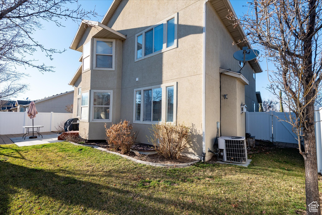 View of home's exterior with a patio, a yard, and cooling unit