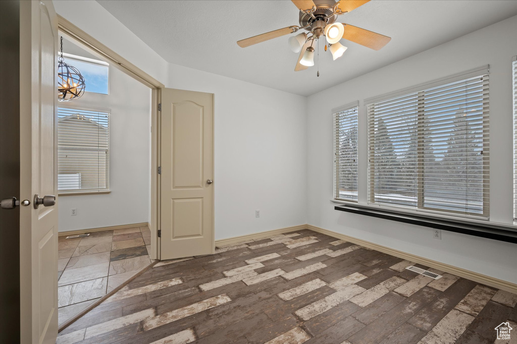 Unfurnished room with wood-type flooring, ceiling fan, and plenty of natural light