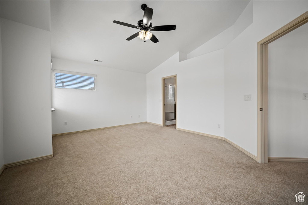 Unfurnished room featuring ceiling fan, lofted ceiling, and light carpet