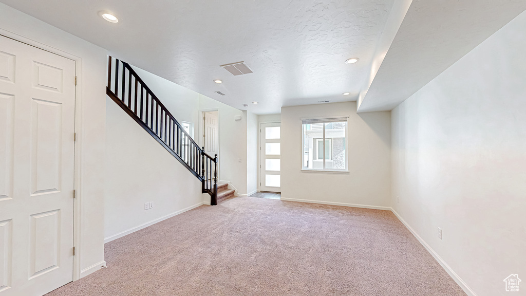 Carpeted foyer entrance featuring a textured ceiling