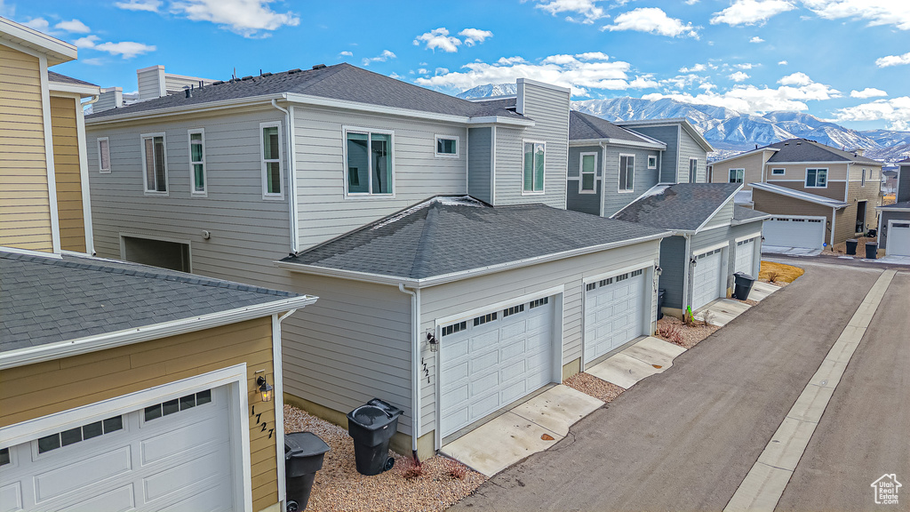 View of side of property featuring a garage and a mountain view