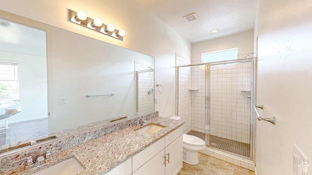 Bathroom with walk in shower, vanity, toilet, and a wealth of natural light