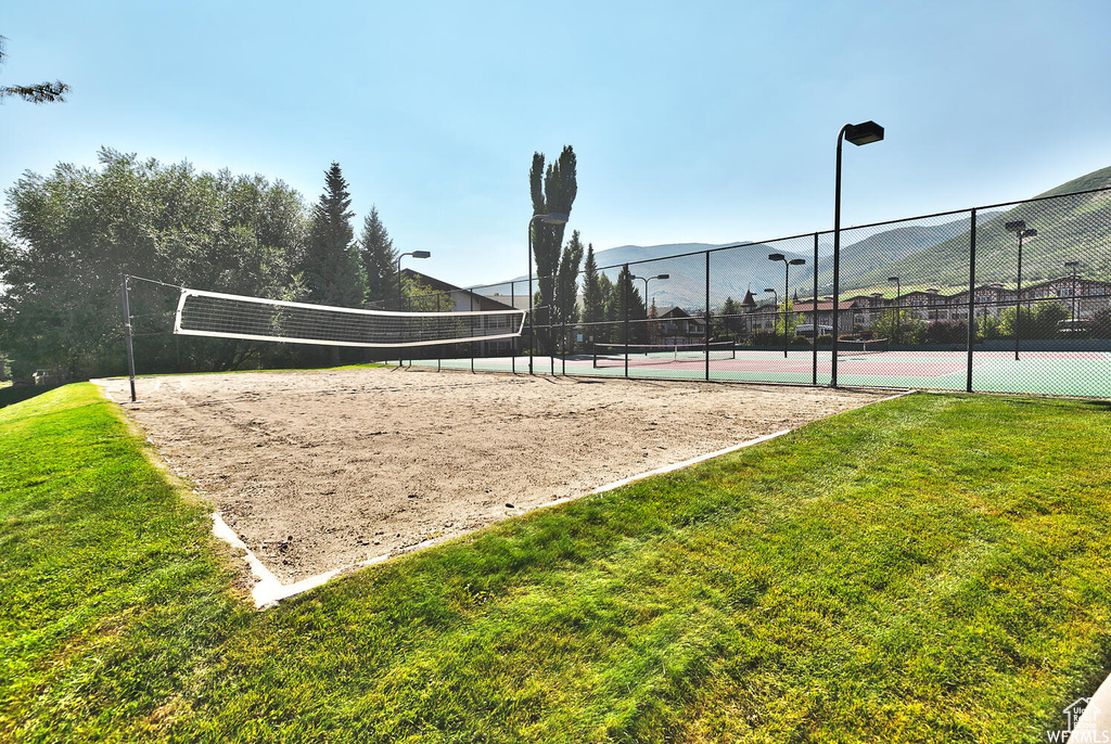 View of community featuring a mountain view, volleyball court, tennis court, and a lawn