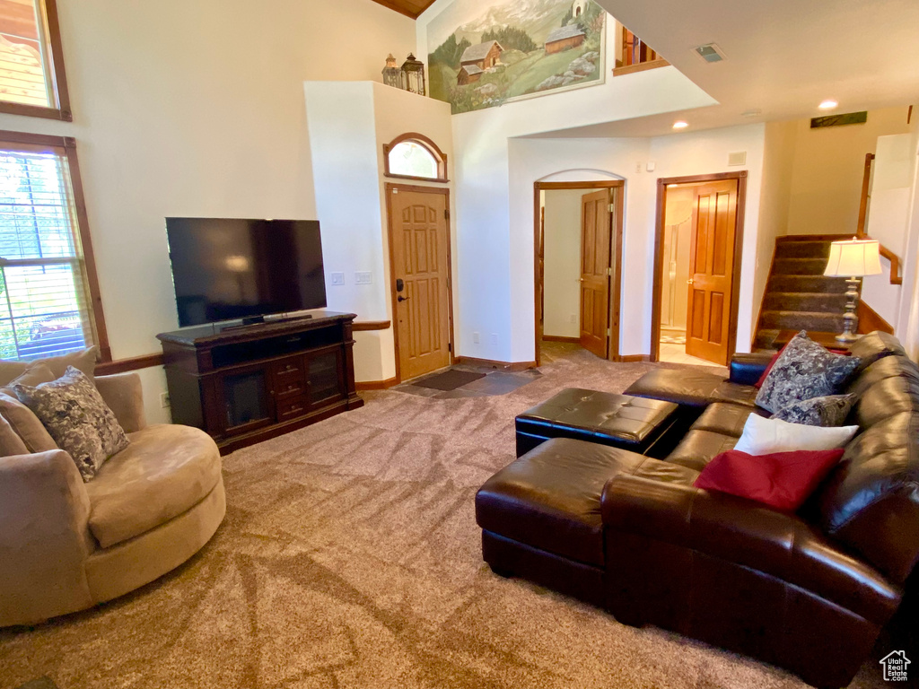 Carpeted living room with a towering ceiling