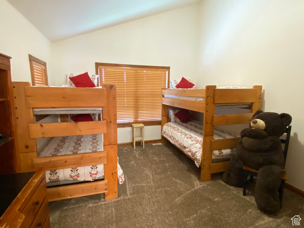 Carpeted bedroom featuring lofted ceiling