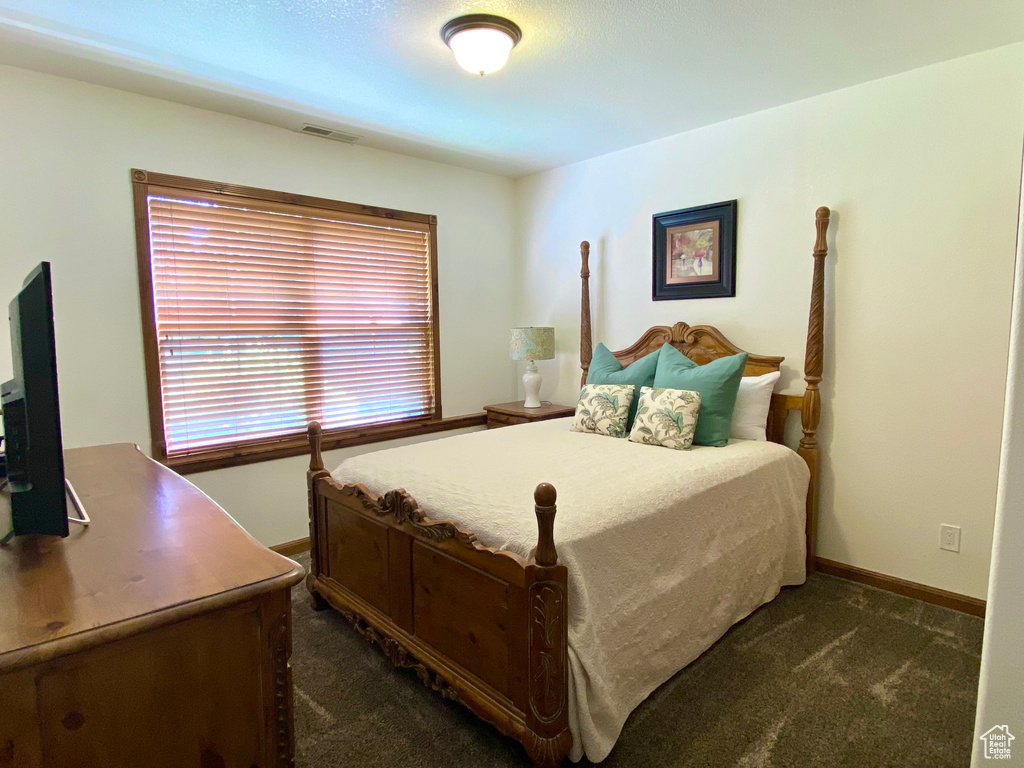 Bedroom featuring dark carpet