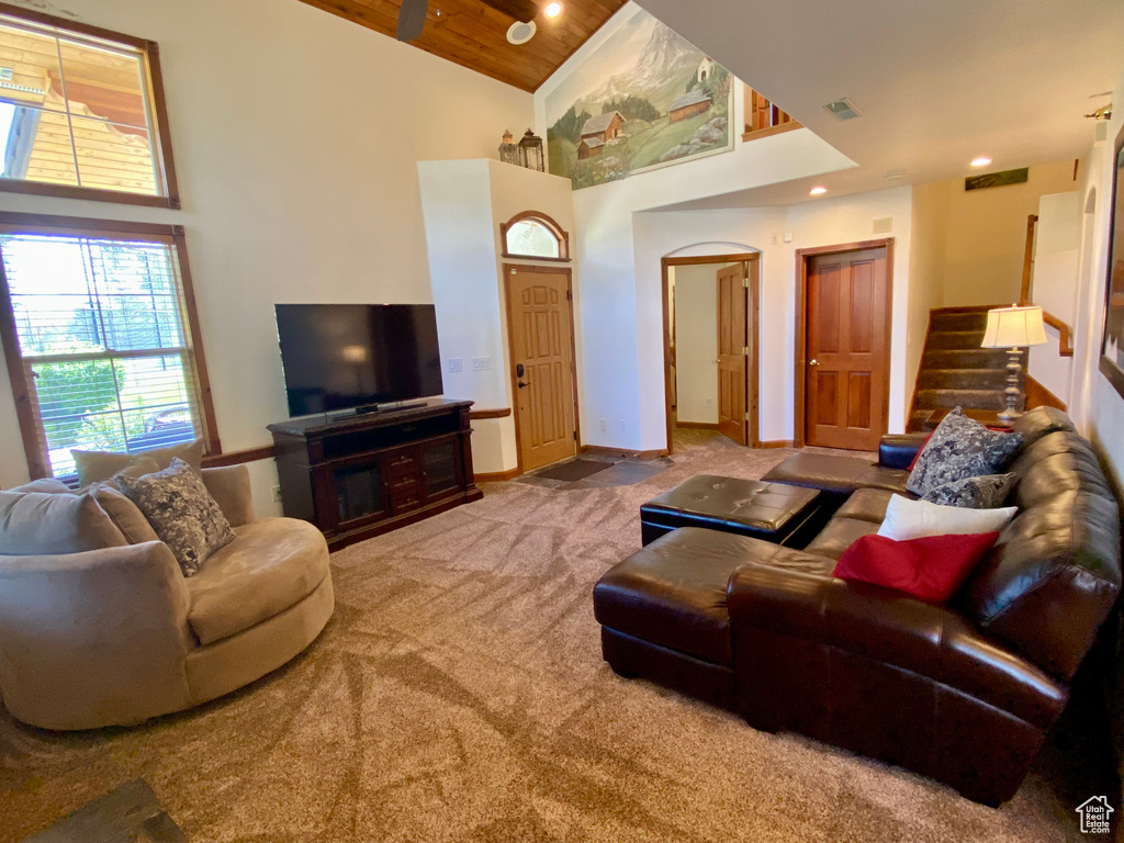 Living room featuring high vaulted ceiling, carpet floors, and wooden ceiling