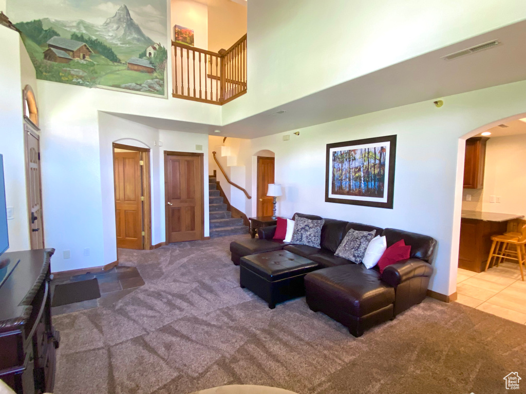 Carpeted living room with a towering ceiling