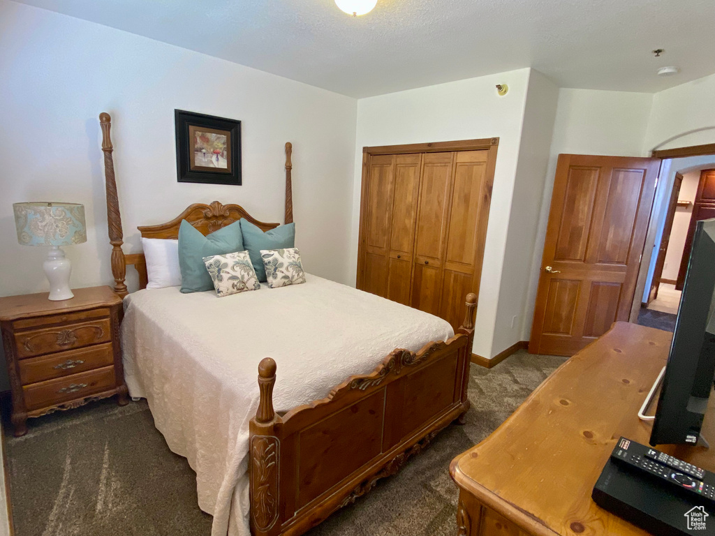 Bedroom featuring a closet and dark colored carpet