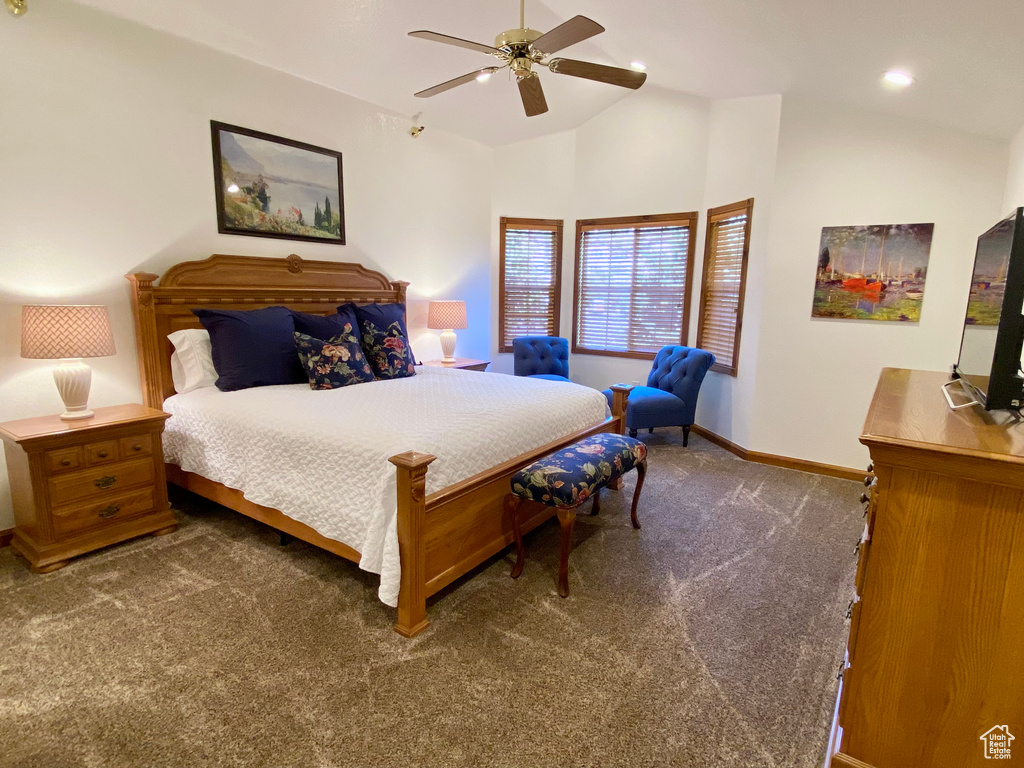 Bedroom with ceiling fan, vaulted ceiling, and dark colored carpet