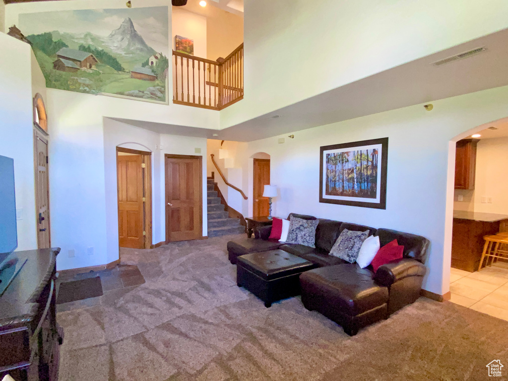 Carpeted living room with a high ceiling