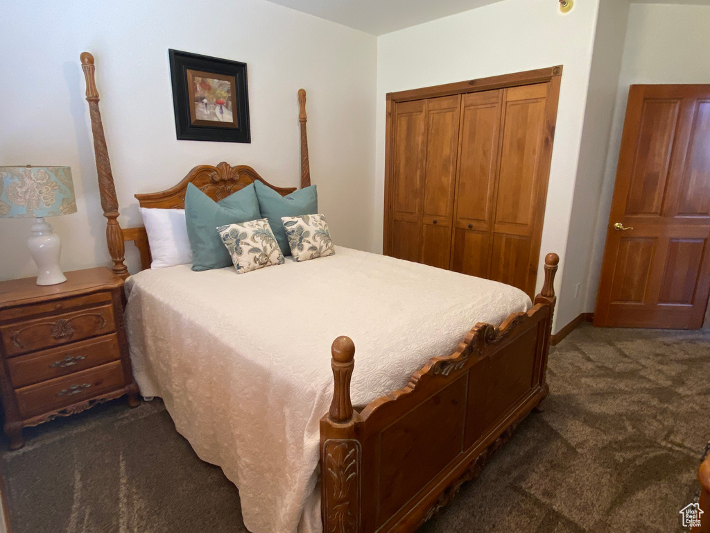 Bedroom featuring a closet and dark colored carpet