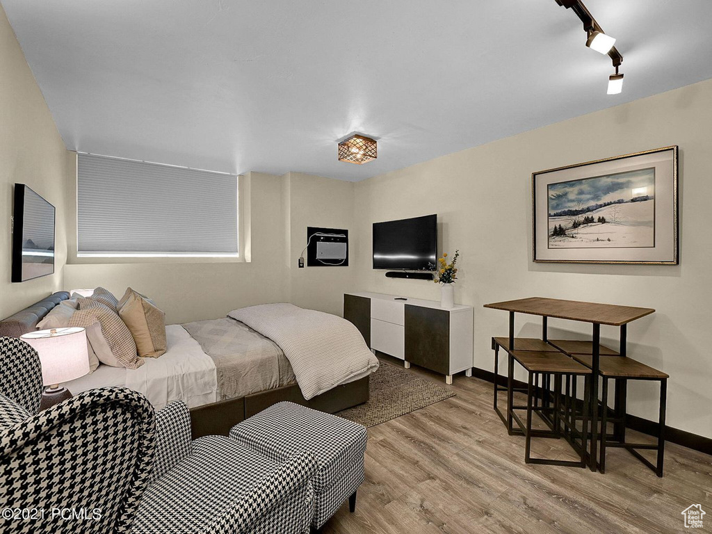 Bedroom featuring light hardwood / wood-style floors and rail lighting