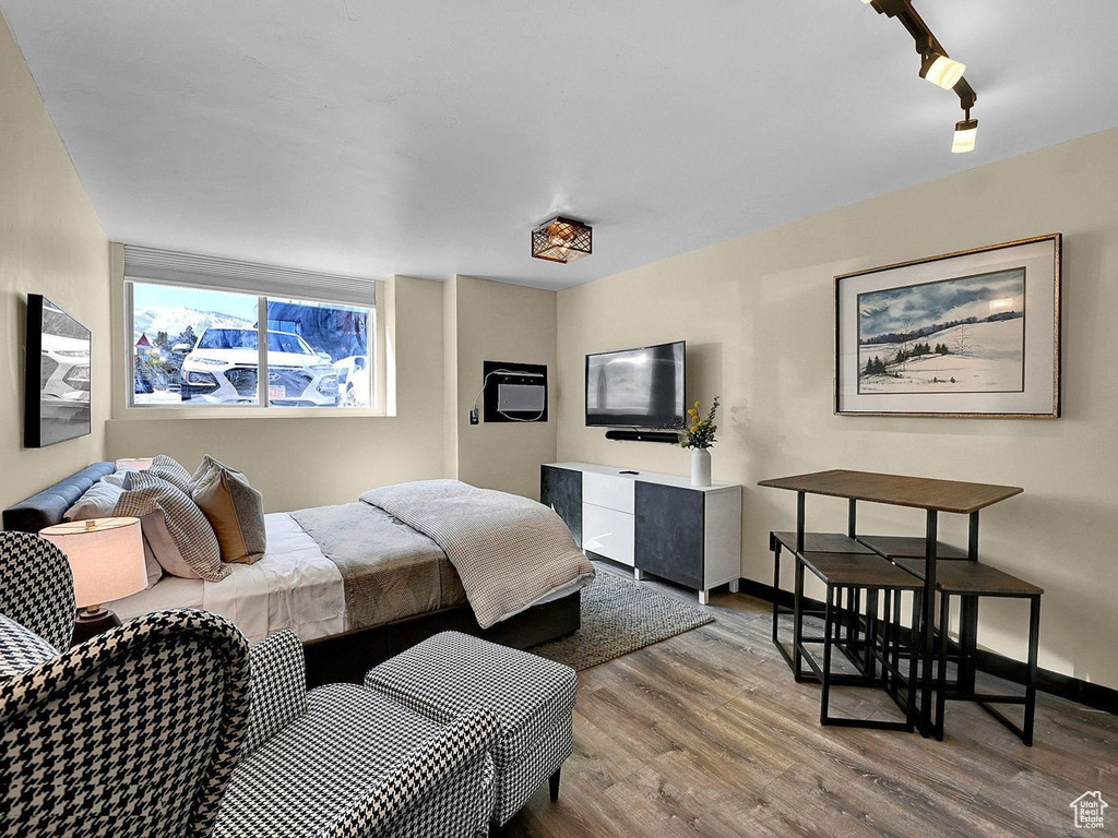 Bedroom with track lighting and hardwood / wood-style floors