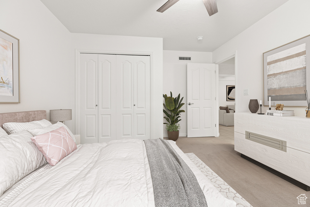 Bedroom with carpet flooring, a closet, and a ceiling fan