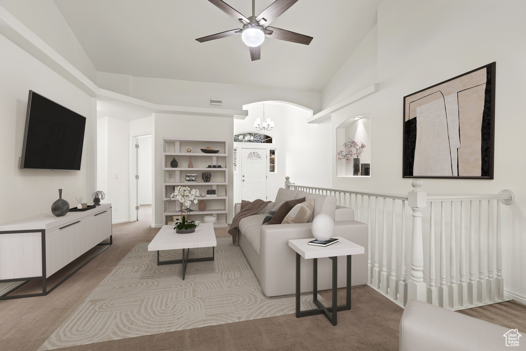Living area featuring a ceiling fan, light carpet, lofted ceiling, a chandelier, and arched walkways