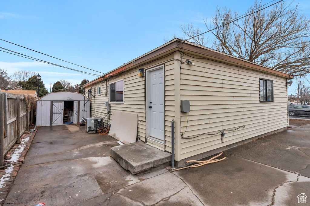 Rear view of property with central AC, a patio, and a shed