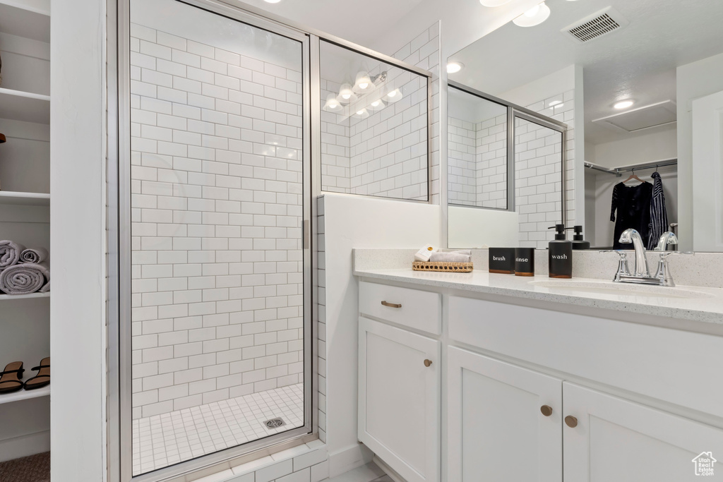 Bathroom featuring vanity and a shower with shower door