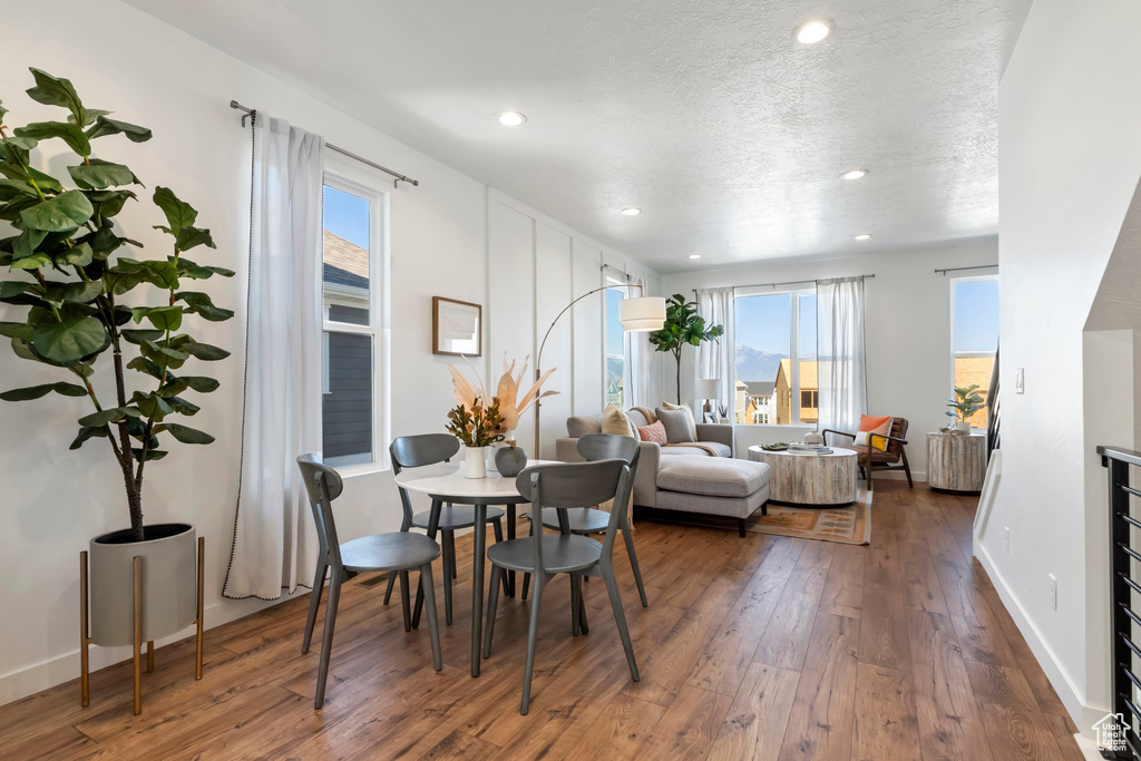Dining area with wood-type flooring and a textured ceiling