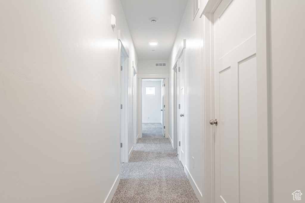 Hall with light carpet and baseboards