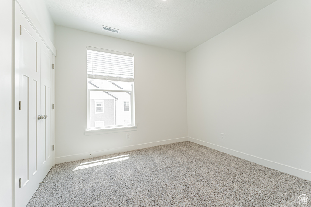 Unfurnished bedroom with carpet flooring and a textured ceiling