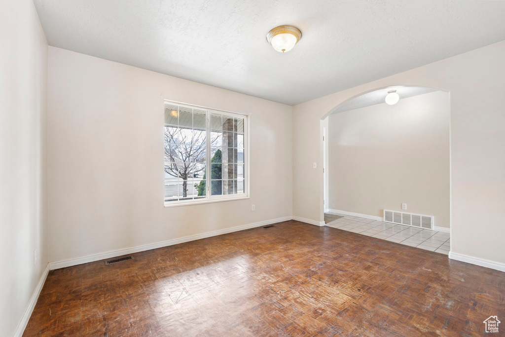 Spare room with parquet flooring and a textured ceiling