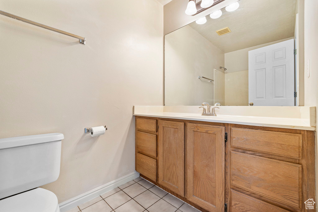 Bathroom featuring tile patterned floors, toilet, and vanity