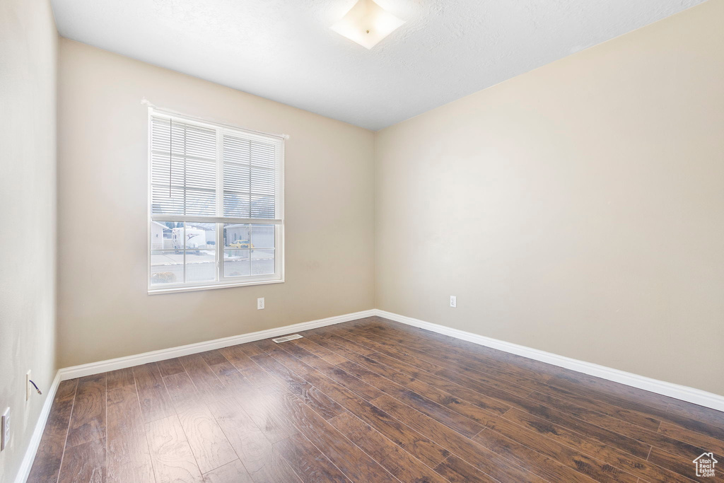 Empty room featuring dark hardwood / wood-style floors